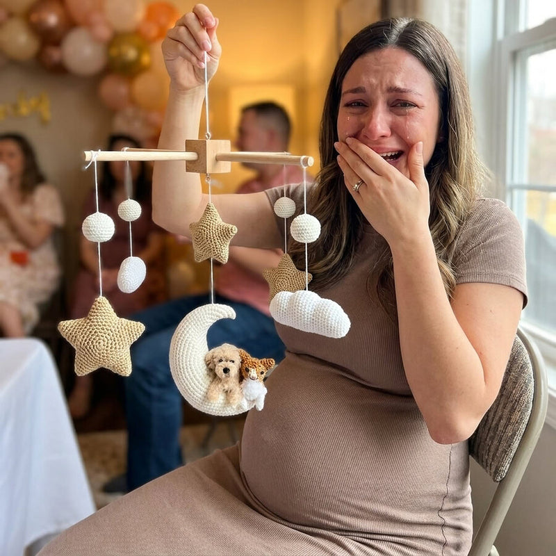 A mother-to-be opening her custom pet nursery mobile at her baby shower