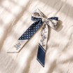 Hand-tied navy polka-dot and cream floral twilly bow